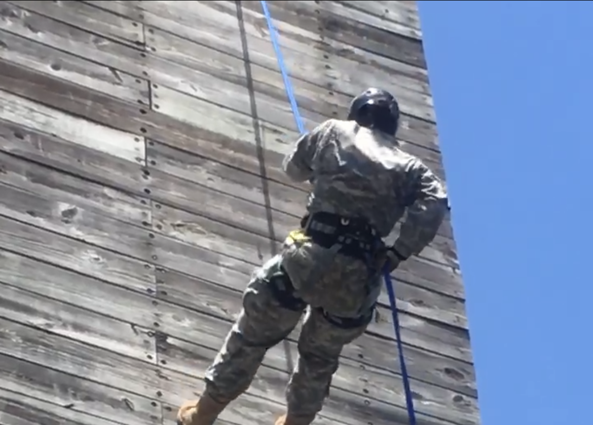 Caroline climbs down a wall wearing Army fatigues, in a photo taken before she developed chronic pain