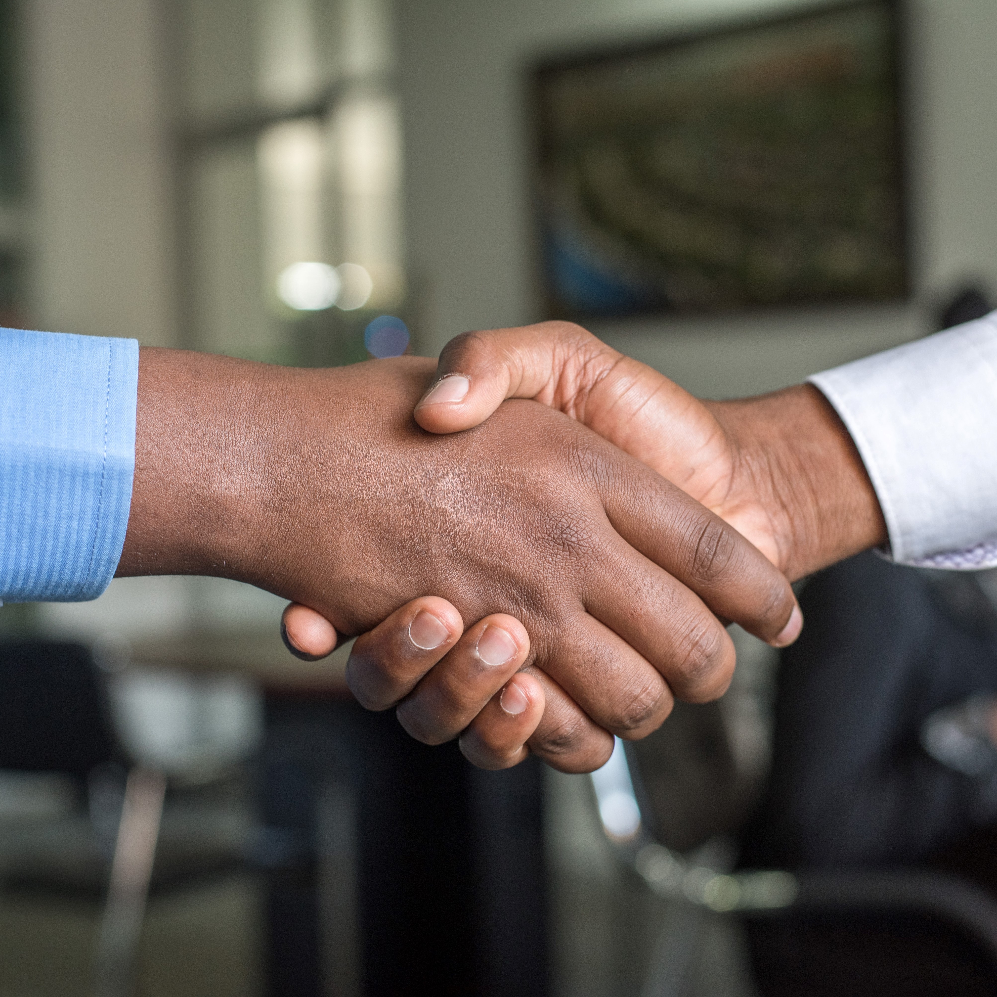 Closeup of a handshake between two brown-skinned hands, as two people meet at the BEYA STEM recruiting conference.