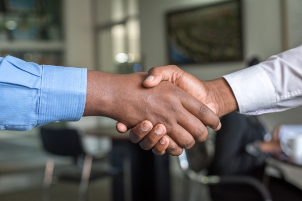 Closeup of a handshake between two brown-skinned hands, as two people meet at the BEYA STEM recruiting conference.
